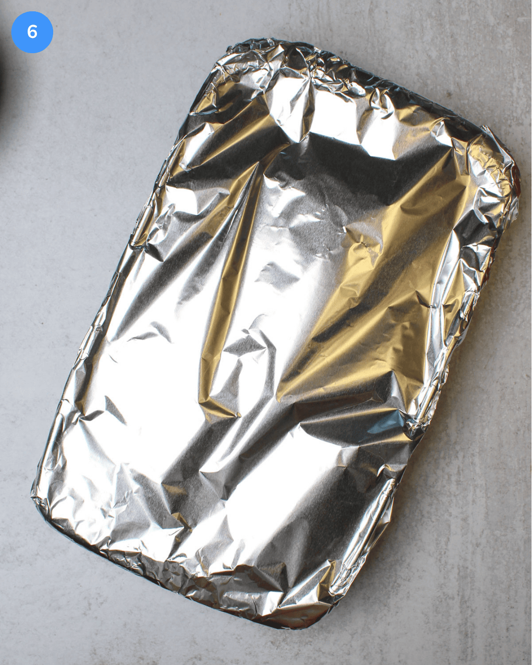 A glass baking dish covered with aluminum foil.