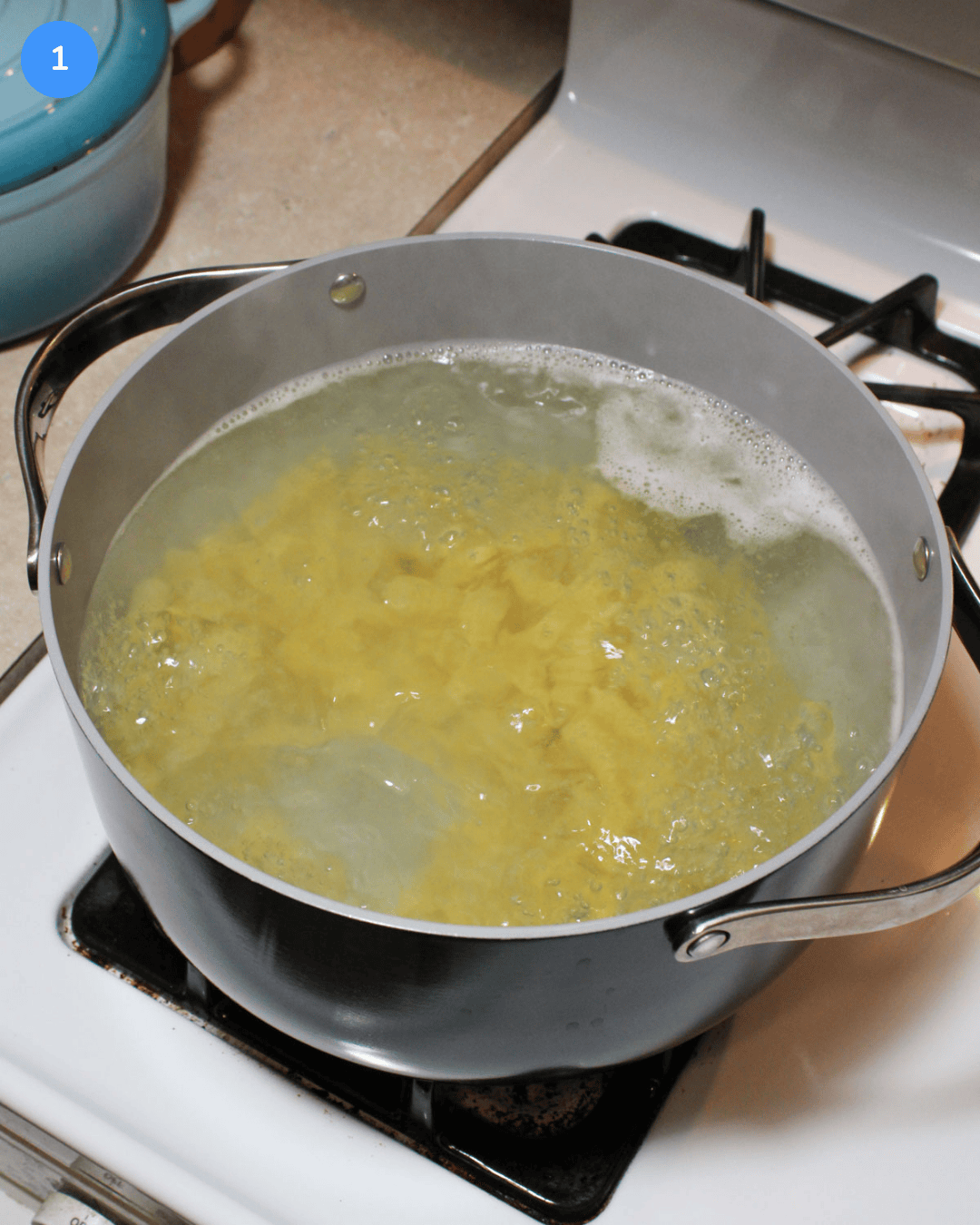 A ceramic pot of boiling pasta on the stove.
