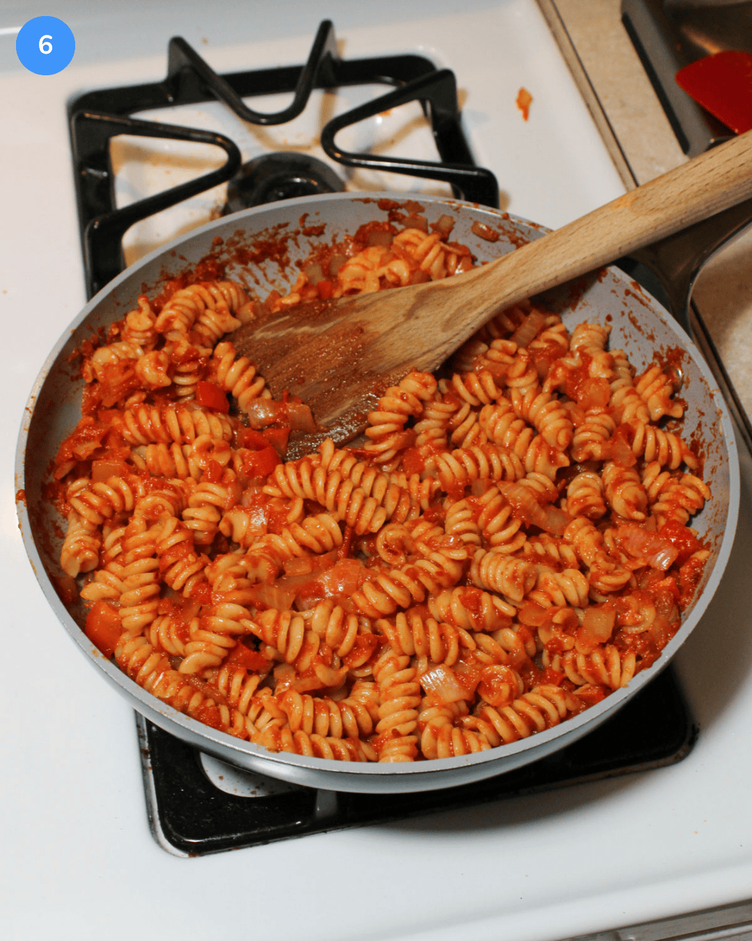 A ceramic frying pan filled with freshly made shakshuka pasta.
