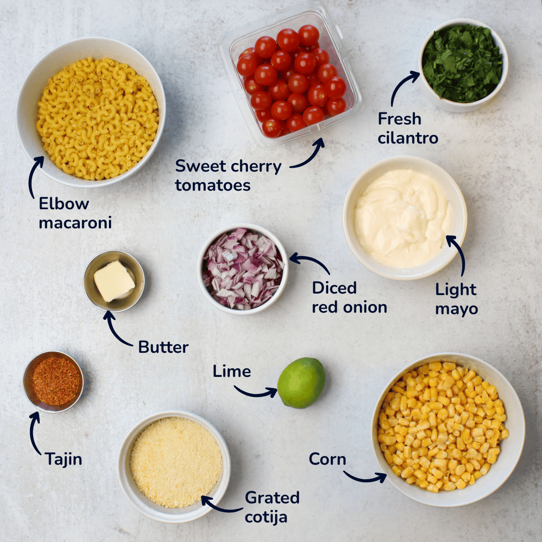 Ingredients for making elote pasta salad: elbow macaroni, sweet cherry tomatoes, fresh cilantro, light mayo, diced red onion, butter, Tajin, grated cotija, lime, corn.