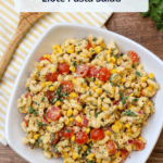 A white ceramic bowl of elote pasta salad with a title overlaid.