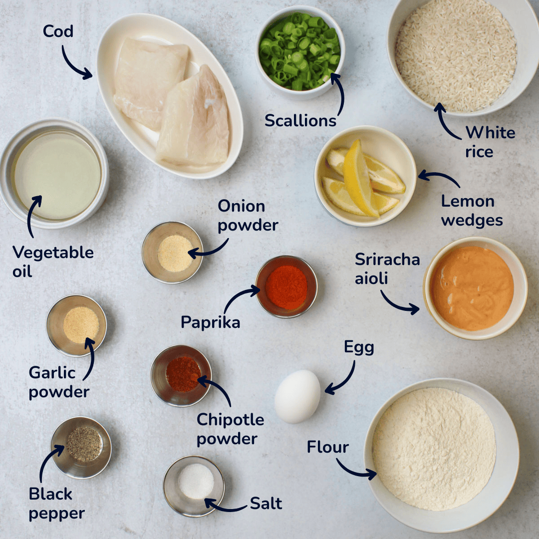 Ingredients for making fried fish rice bowls: cod, scallions, white rice, lemon wedges, vegetable oil, onion powder, garlic powder, paprika, chipotle powder, salt, black pepper, egg, flour, and sriracha aioli.