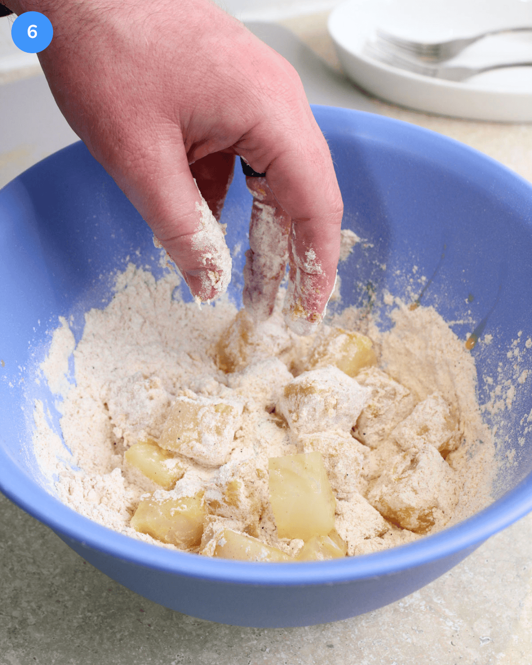 Bite size pieces of cod fish being dredged in flour.