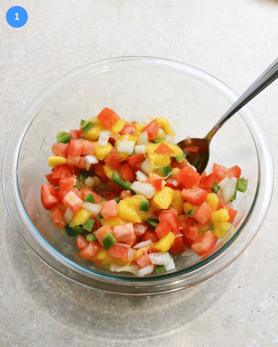 Step 1 of making fried fish tacos. Mango pico de gallo in a mixing bowl.