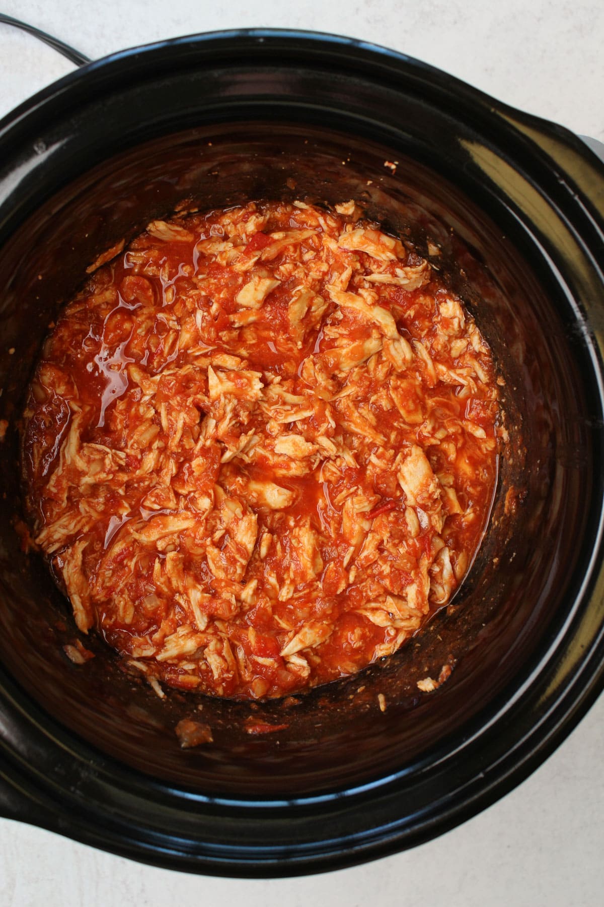 A crockpot full of freshly cooked gochujang chicken.