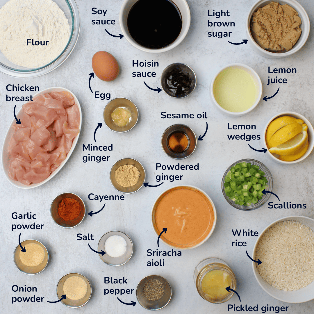 Ingredients for making japanese crispy chicken rice bowls: flour, soy sauce, light brown sugar, lemon juice, hoisin sauce, egg, chicken breast, minced ginger, sesame oil, powdered ginger, cayenne, garlic powder, onion powder, salt, black pepper, sriracha aioli, scallions, lemon wedges, pickled ginger, and white rice.