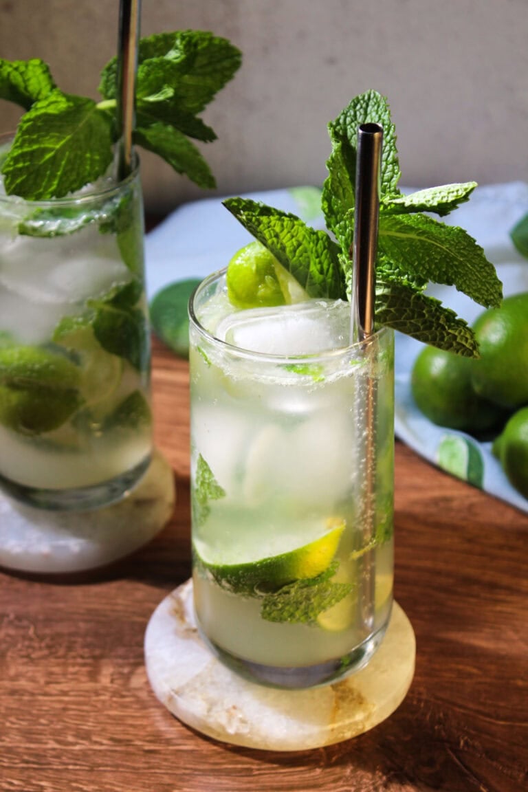 Two mojito mocktails served in tall glasses with fresh mint sprigs.