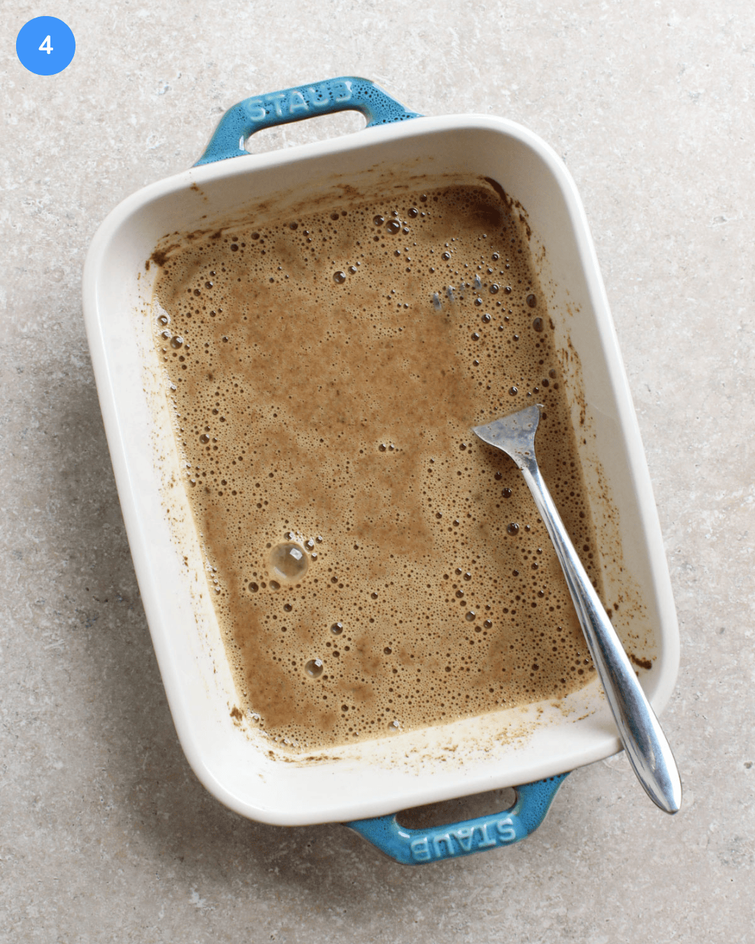 A small ceramic dish with a French toast custard mixture in it.