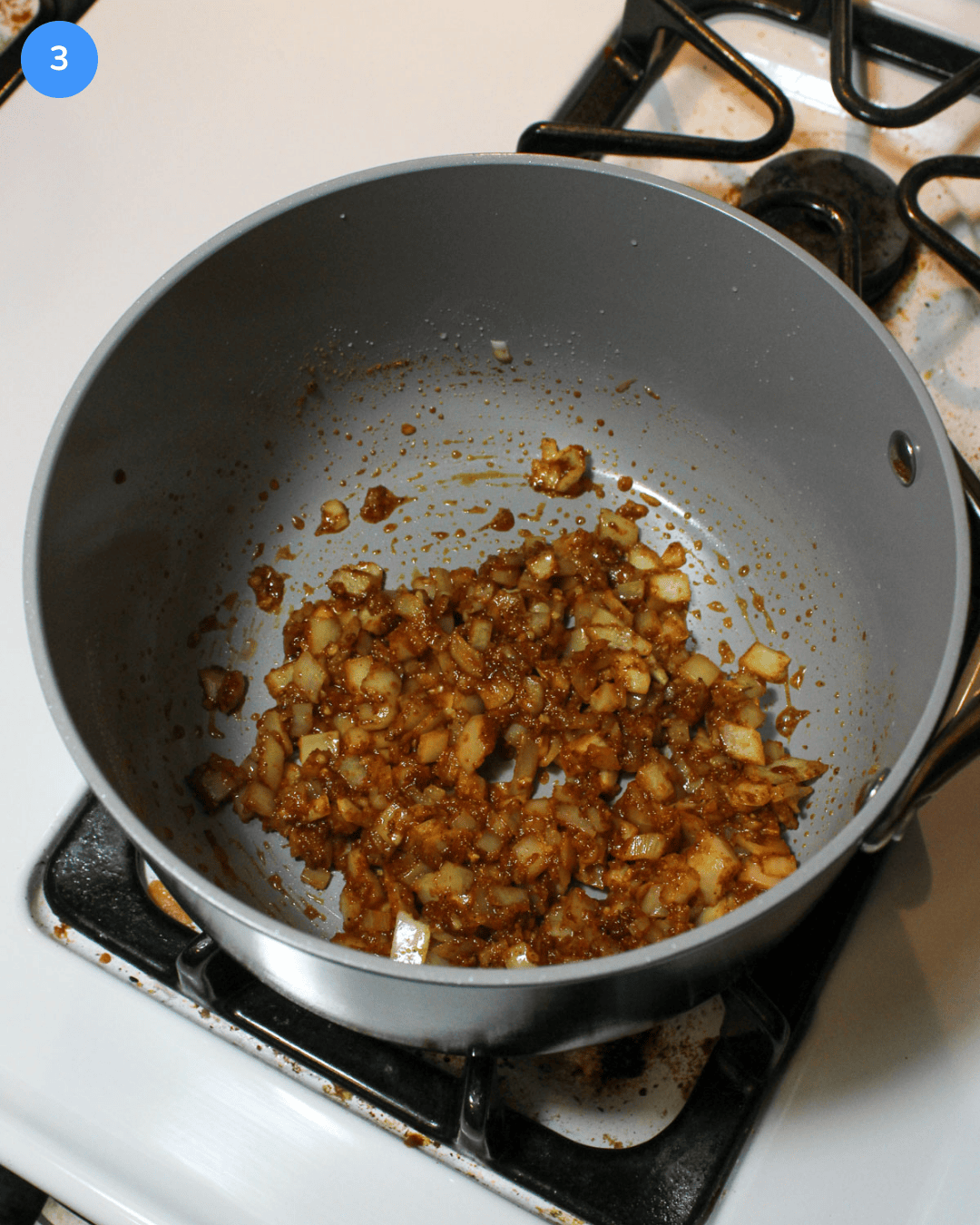 Step 3: Sauteed minced garlic and diced onion in a sauce pot coated in a seasoning mixture.