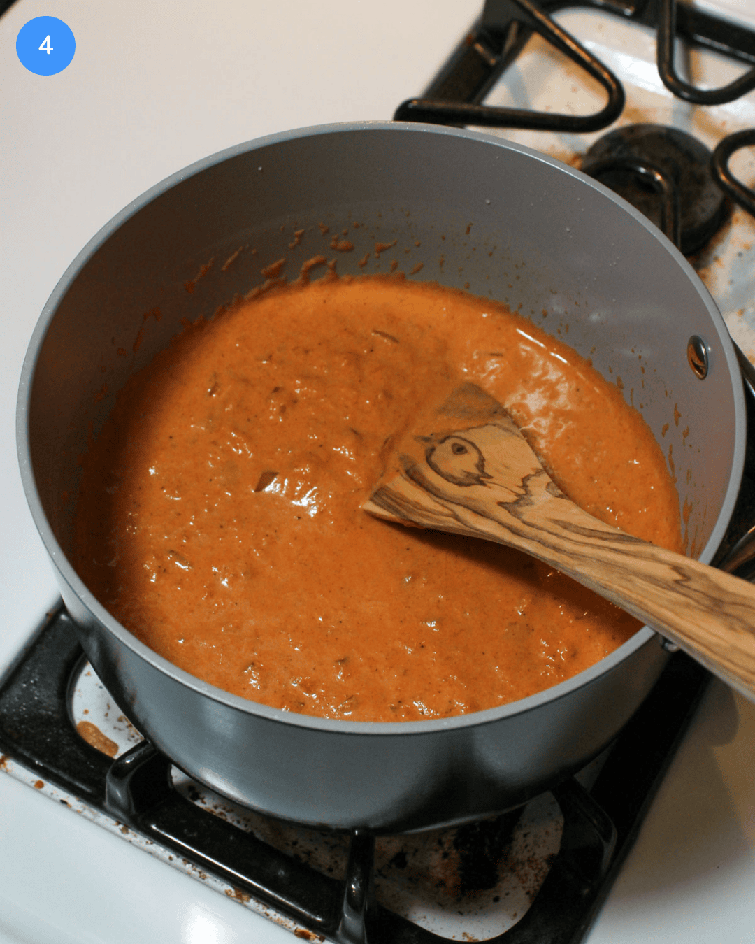 Step 4: A sauce pot of a red tikka masala sauce being cooked.