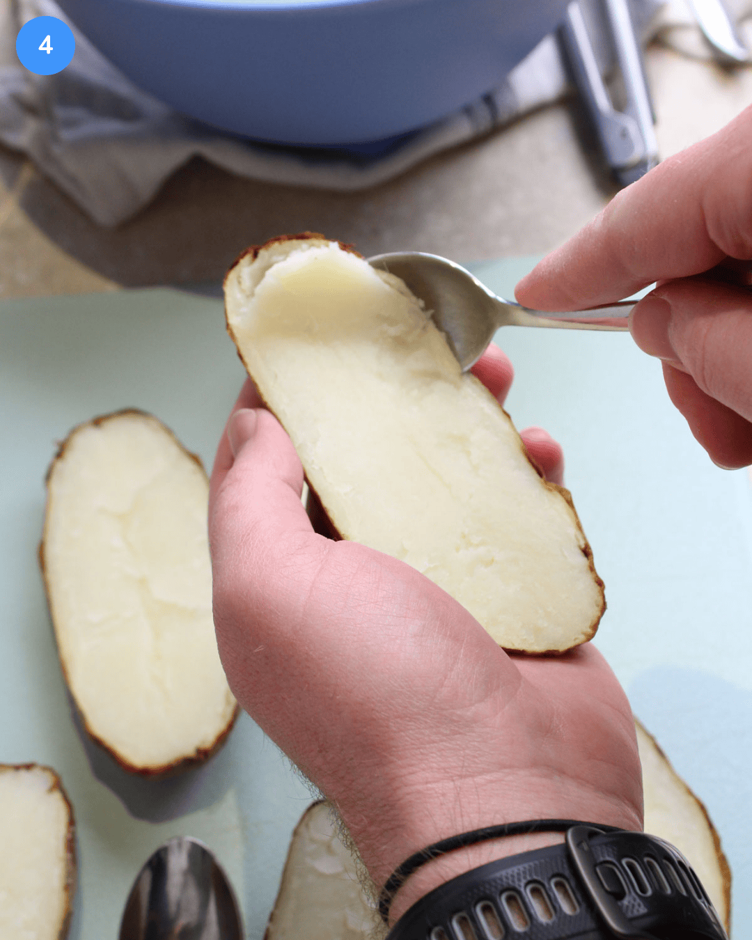 Step 4: An air fried russet potato half being held and scooped out with a spoon.