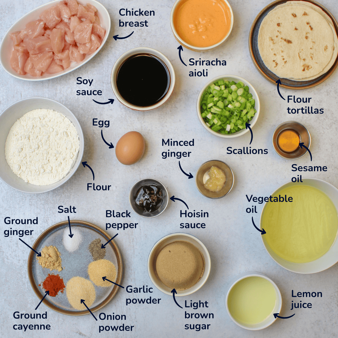 Ingredients for making asian fried chicken tacos: chicken breast, soy sauce, egg, flour, minced ginger, hoisin sauce, light brown sugar, lemon juice, sesame oil, salt, pepper, garlic powder, onion powder, ground cayenne, ground ginger, vegetable oil, scallions, sriracha aioli, and flour tortillas.