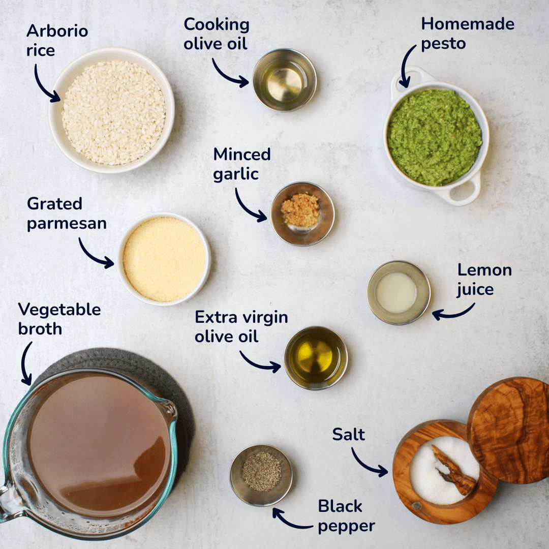 Pesto risotto ingredients shot showing arborio rice, pesto, olive oil, parmesan, lemon juice, garlic, salt, vegetable broth, and black pepper.