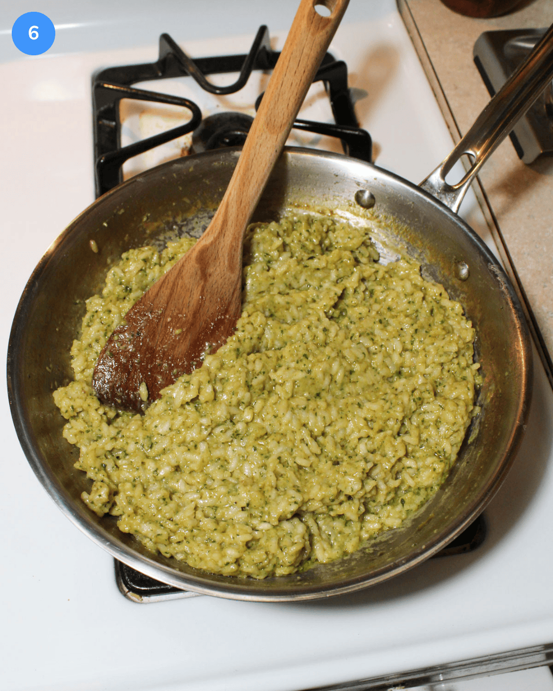 Pesto risotto step 6: the rice now with the pesto, salt, and pepper stirred into it in the pan.