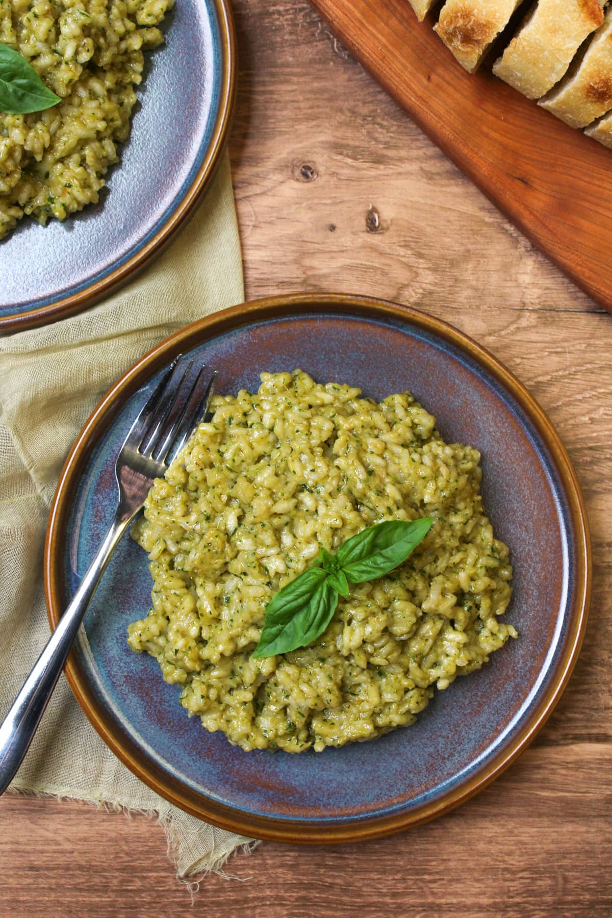 A plate of homemade pesto risotto garnished with fresh basil.