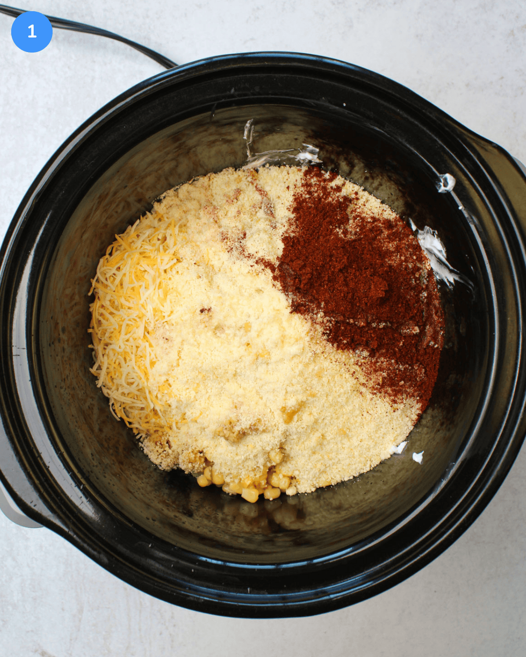 Step 1 of Mexican street corn dip: all ingredients are shown in the slow cooker.