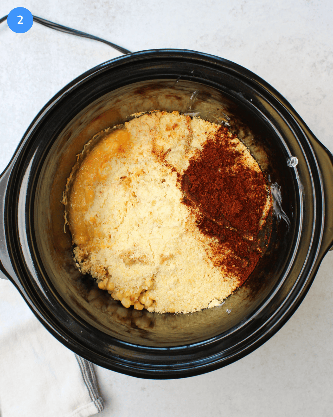 Step 2 of Mexican street corn dip: All ingredients are shown in the slow cooker after an hour of cooking, the cheese is melted.