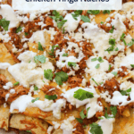A pinterest cover image of chicken tinga nachos made with crockpot chicken tinga, mexican cheese, crema, and queso fresco.