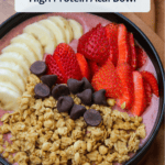 A frozen acai smoothie bowl with strawberries, bananas, granola, and chocolate chips on top, with a title overlaid.