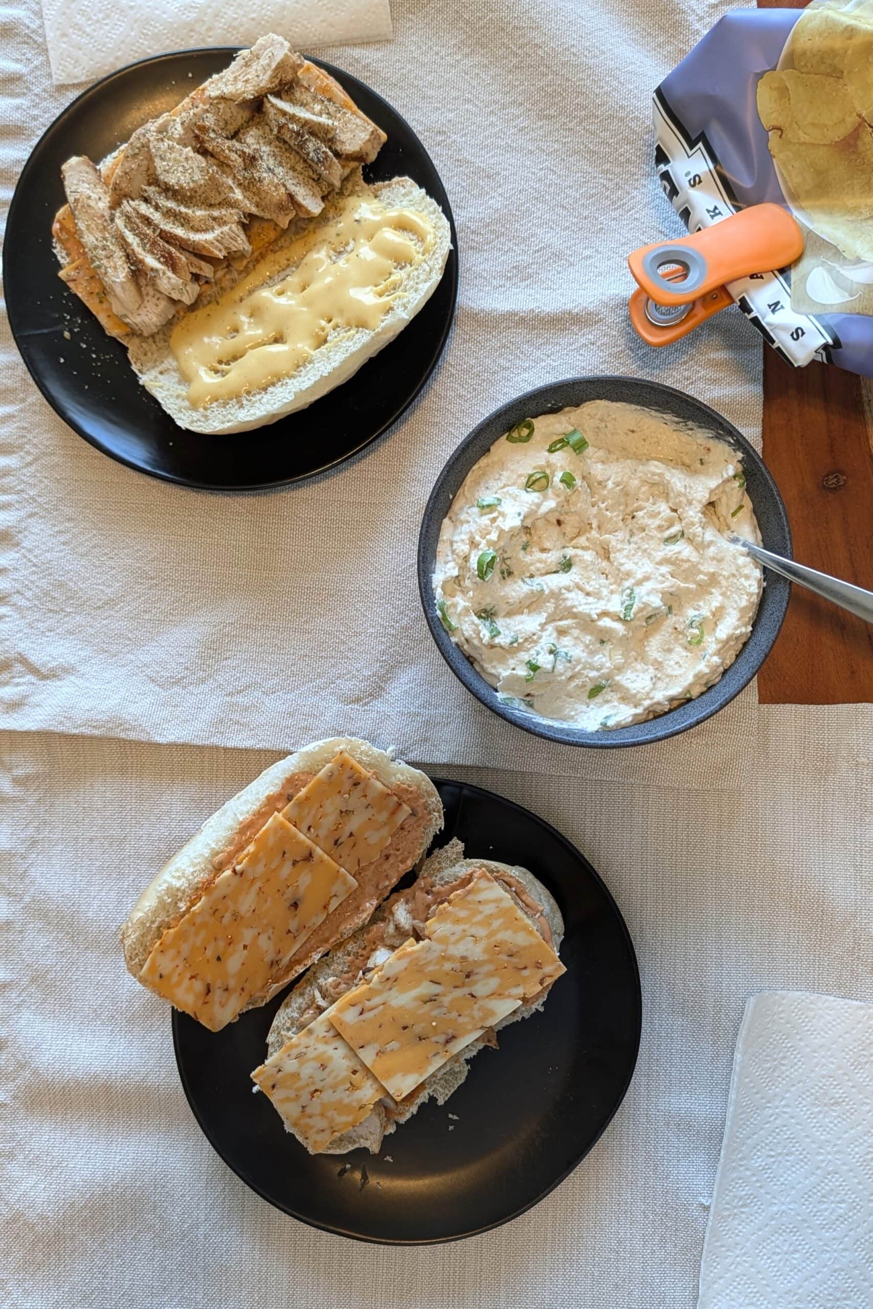 Two sandwiches and a bowl of creamy onion dip.