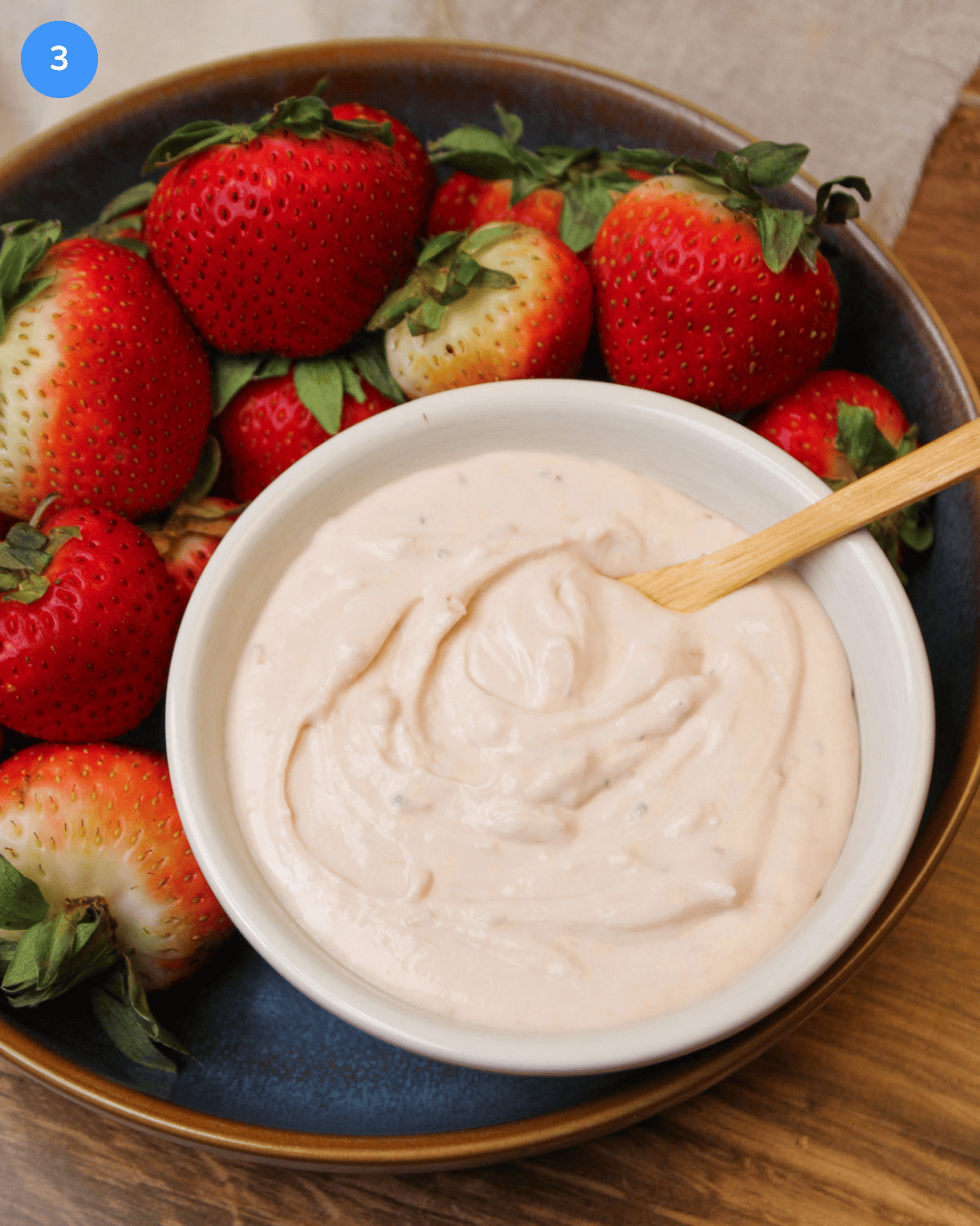A bowl of chilled strawberry dip served with fresh, ripe strawberries.