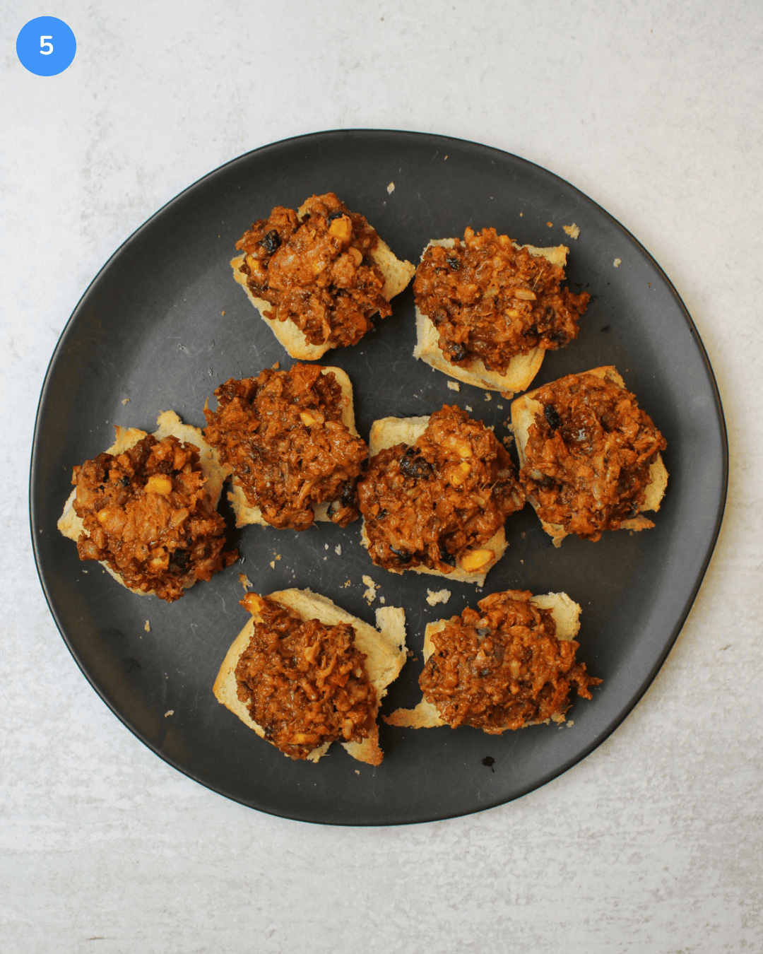 A black plate of vegetarian black bean sliders.