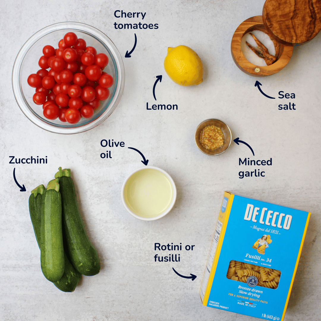 Ingredients for making zucchini tomato pasta: cherry tomatoes, zucchini, olive oil, lemon, minced garlic, sea salt, and rotini or fusilli pasta.