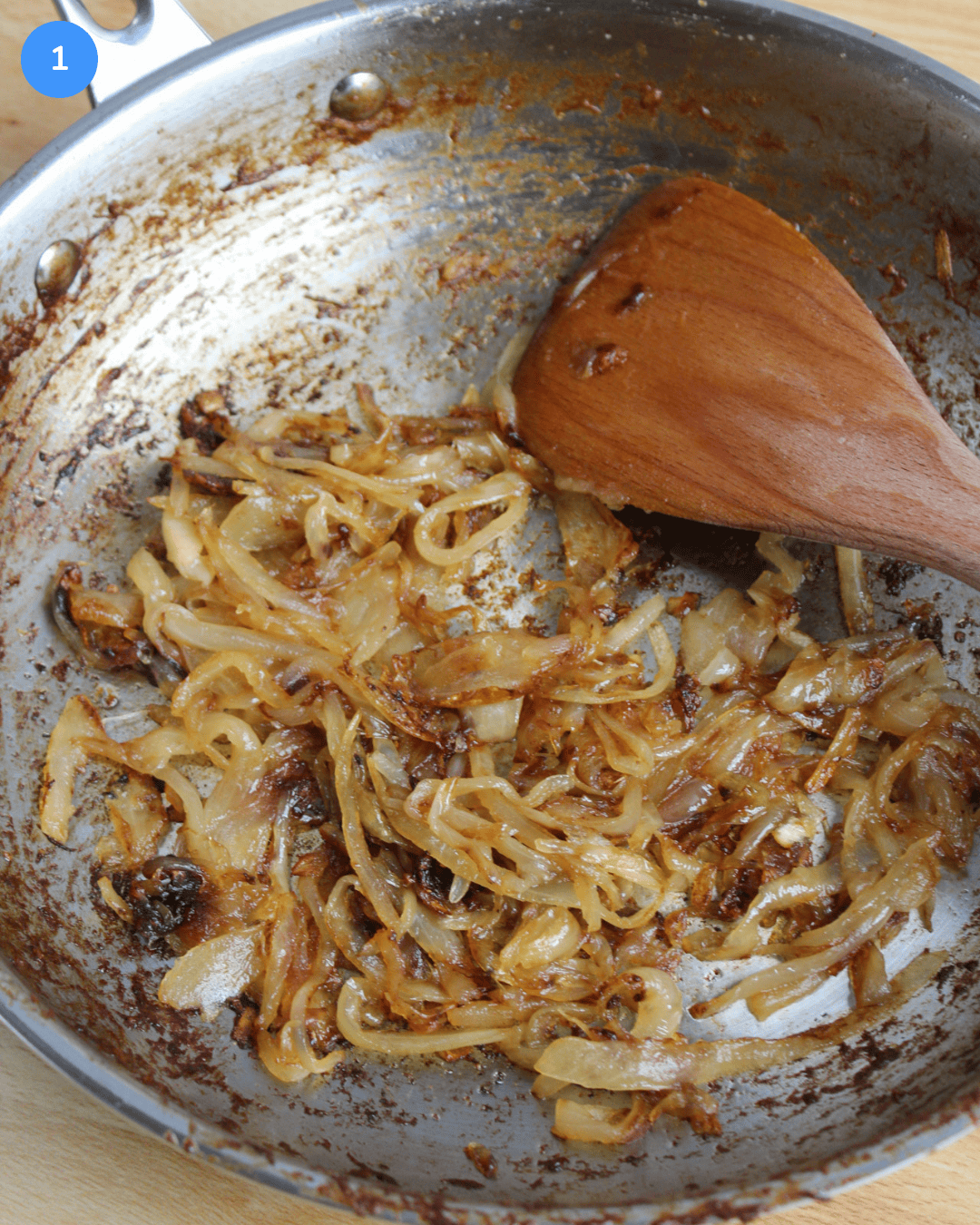 Freshly cooked caramelized onions in a stainless steel frying pan.