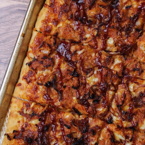 A freshly baked, golden brown crust barbecue pulled pork pizza.