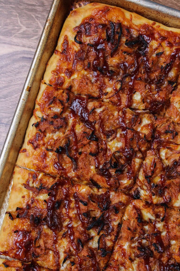 A freshly baked, golden brown crust barbecue pulled pork pizza.