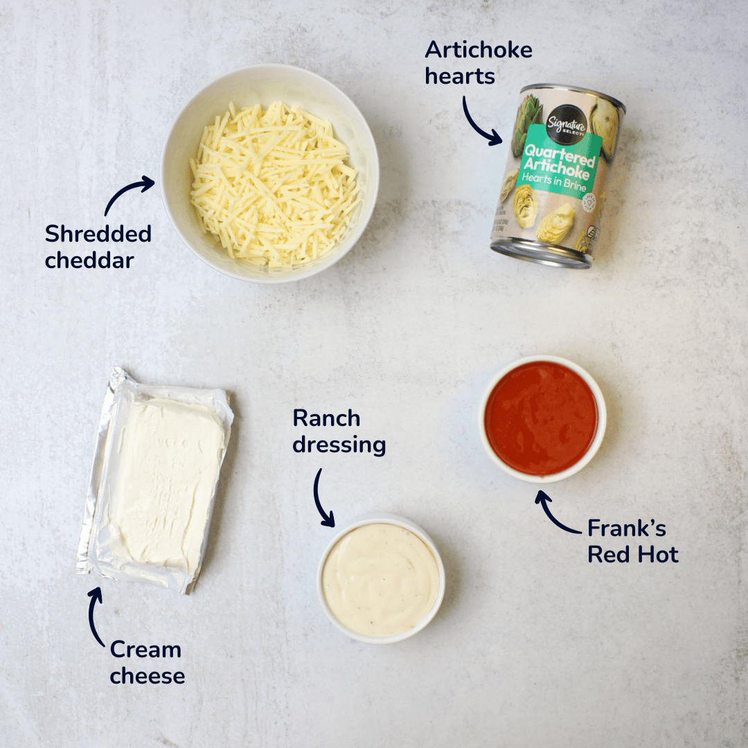 Ingredients for making buffalo artichoke dip: artichoke hearts, shredded cheddar, cream cheese, ranch dressing, frank's red hot.