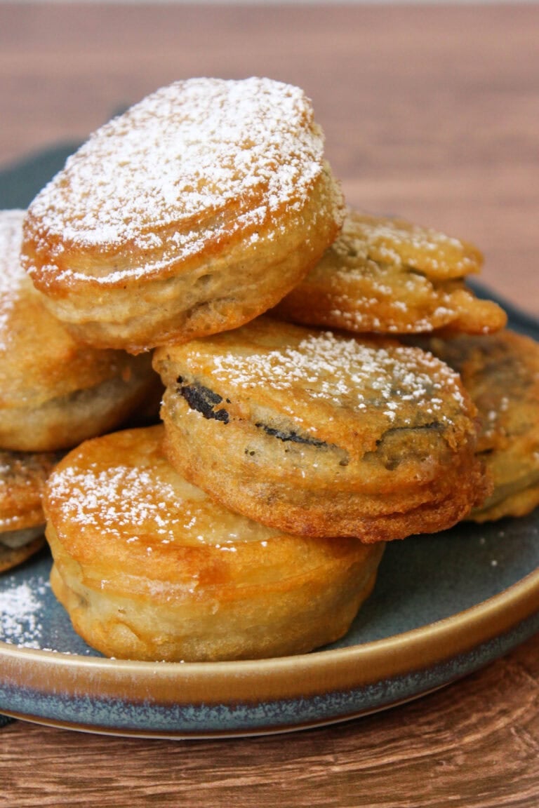 A pile of perfectly golden brown fried oreos on a blue stoneware plate.