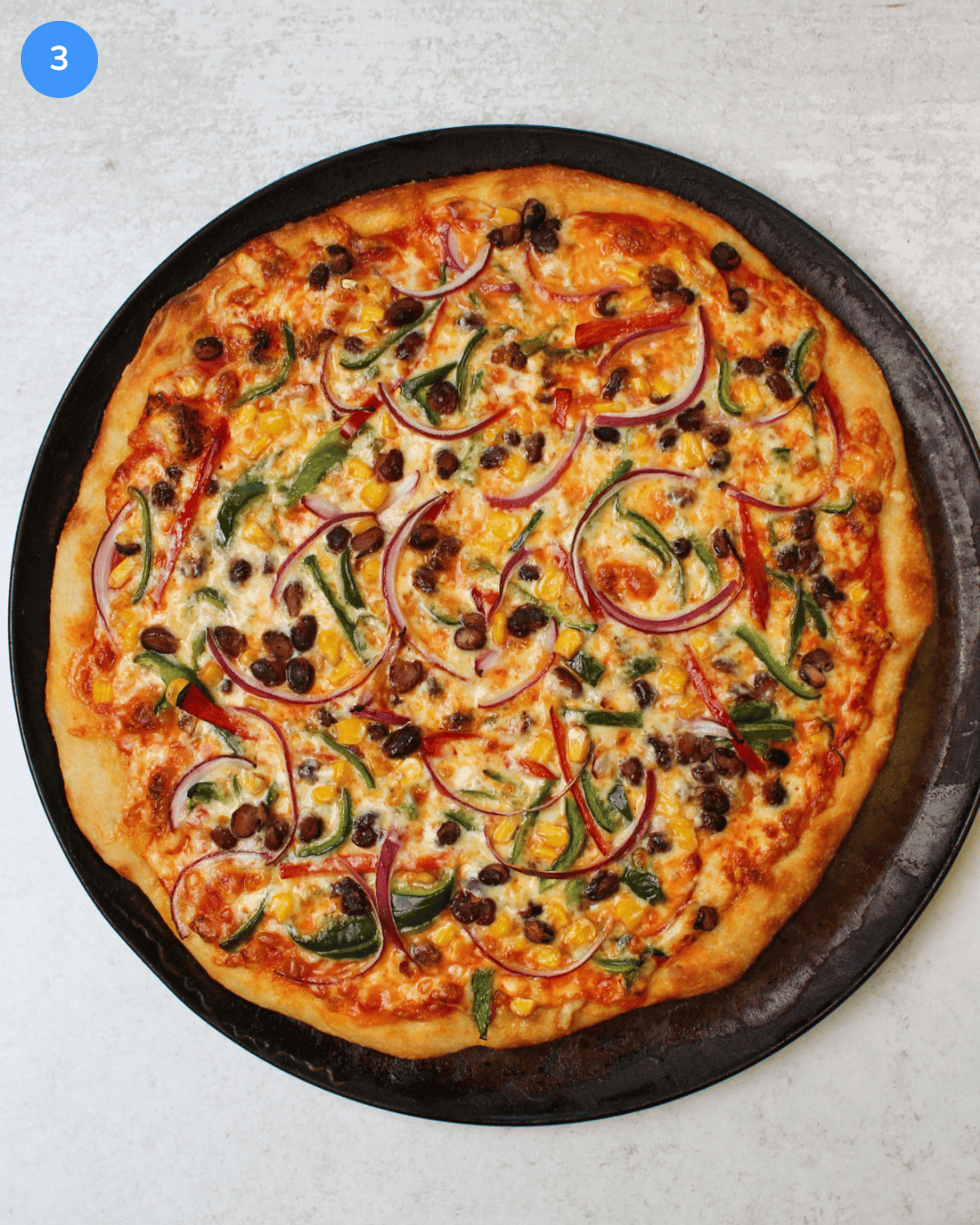 A freshly baked southwest veggie pizza with golden brown crust on a round pizza pan.
