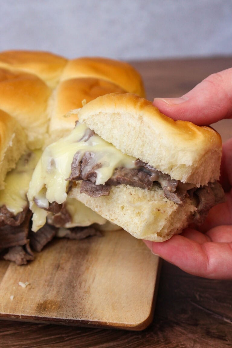 A freshly made philly cheesesteak slider on a hawaiian roll.