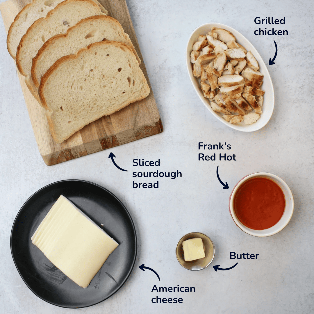 Ingredients for making buffalo chicken grilled cheese: sliced sourdough bread, american cheese, butter, grilled chicken, and frank's red hot.